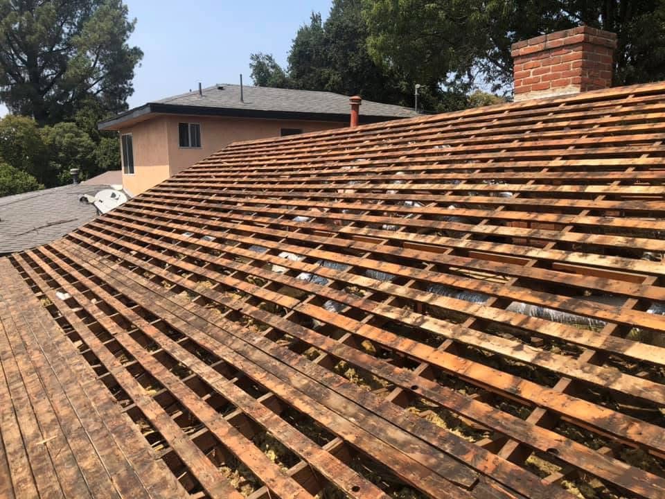 Roof stripped down to bare wood sheathing during tear-off, before new underlayment and shingles